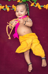 cute Indian boy dresses as lord rama with bow and flowers from top angle