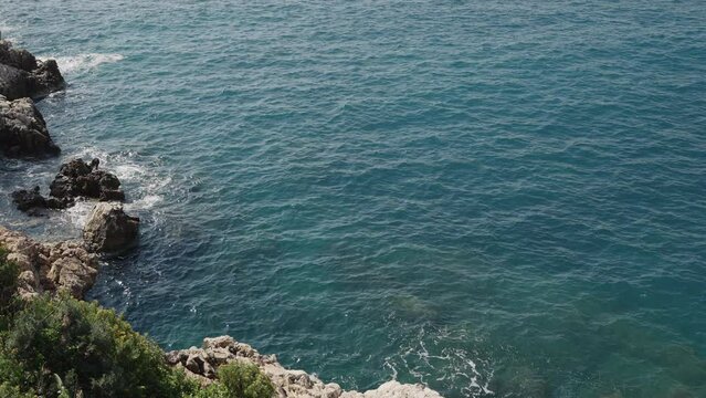 Slow motion waves of mediterranean sea splashing on coastline of French Riviera
