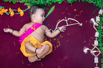 cute Indian boy dresses as lord rama with bow and flowers from top angle