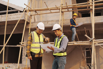 Team of engineer and worker checking construction site outdoors Surveyor builder Engineer surveying work checking schedule for rebuilding project. © Phushutter