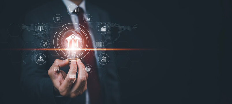 Businessman holding glowing light bulb with shows light bulb with bank icons outline,finance and banking digital, Finance and banking networks, Digital marketing, cyber security, Business technology. - Powered by Adobe