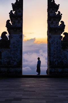 Man in Pura Lempuyang temple Gate at sunset.