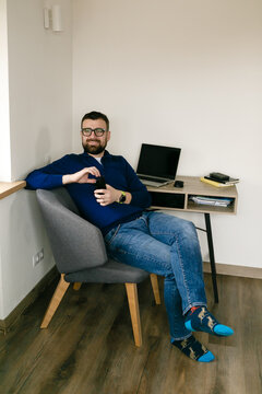 man sits at a desk with a laptop and books and thinks about business