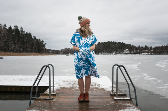 woman standing on a dock ready to go cold water swimming