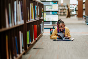 Young Black girl reading library book