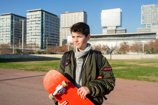 Shot of a young man holding a skateboard outside.