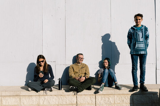 Happy Father And Kids Hanging Out On A wall In The Sun