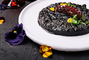 Cooked octopus and black rice in plate