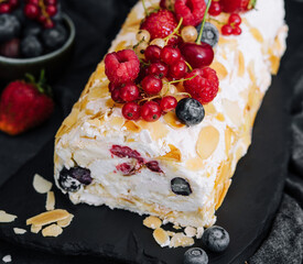 Meringue roll with cream and berries and almonds