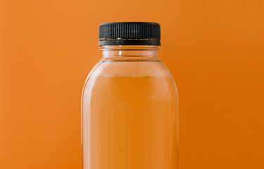 Bottle of fresh orange juice on yellow background