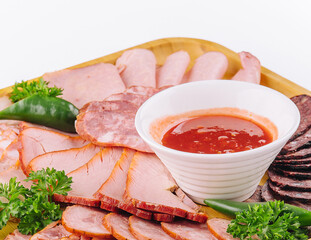 Assorted deli cold meats on wooden tray
