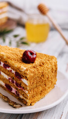 Homemade honey cake with cherry on plate