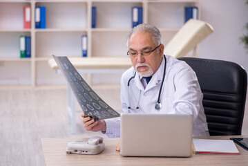 Old male doctor radiologist working in the clinic