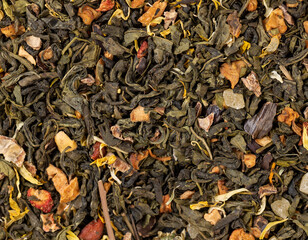 A large amount of dry green tea with pieces of fruit