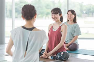 ヨガ教室・ピラティスでヨガを習う女性達
