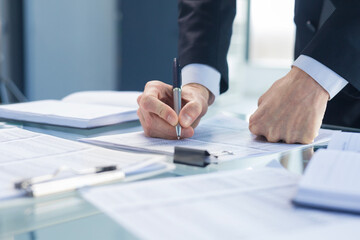 Unrecognizable business person analyzing graphs.