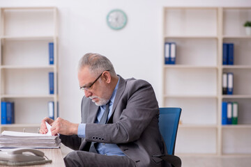 Old male employee working in the office