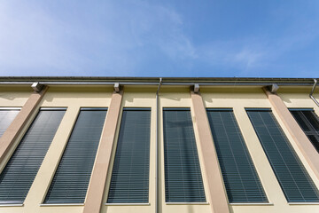 The facade of the sports hall with large windows covered with blinds.