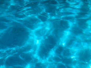 Fototapeta na wymiar Dramatic blue swimming pool water surface dazzling reflection