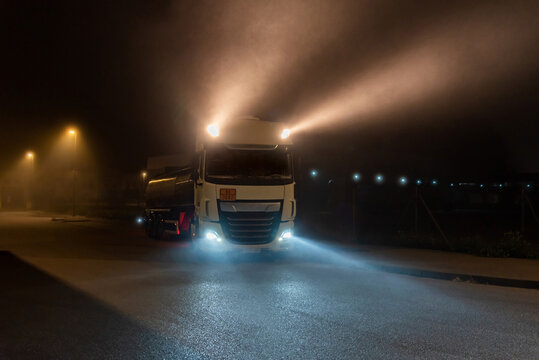 Tanker truck with dangerous goods on a foggy night with high beams on.