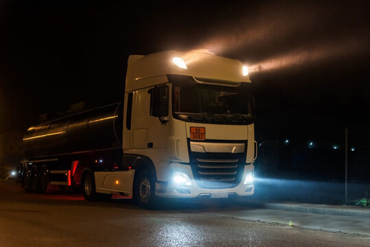 Tanker truck with dangerous goods on a foggy night with high beams on.