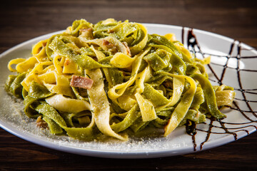 Tagliatelle with parmesan and bacon on wooden table

