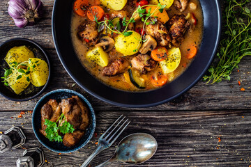 Delicious stew - cooked vegetables with roast meat on wooden table
