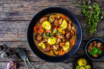 Delicious stew - cooked vegetables with roast meat on wooden table
