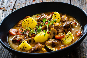 Delicious stew - cooked vegetables with roast meat on wooden table
