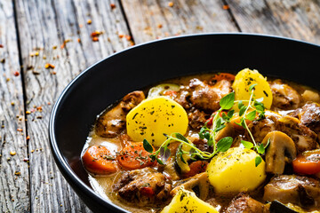 Delicious stew - cooked vegetables with roast meat on wooden table

