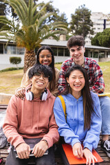 Multi ethnic portrait of young group of happy student friends smiling at camera from college campus