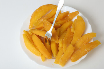 slices of yellow mango closeup photo in plate on white background