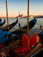 Venezia. Arredo di gondola al palo verso l'Isola di San Giorgio Maggiore al tramonto.
