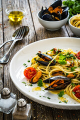Noodles with clams on wooden table
