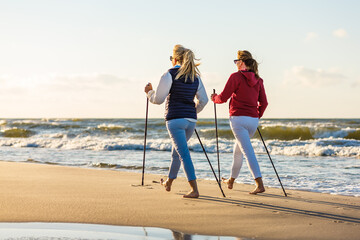 Nordic walking - two women training on beach
