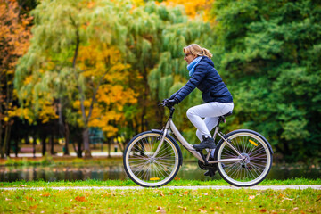 Obraz premium Woman riding bicycle in city park 