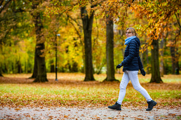 Fototapeta premium Beautiful woman walking in city park 