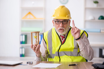 Old male architect in time management concept