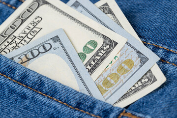 cash American hundred dollar bills lying in the pocket of jeans