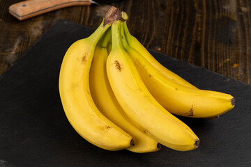 a branch of fresh bananas on the table