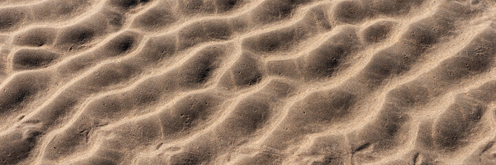 Panoramic image. Beach sand texture. Wavy sandy background