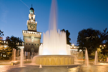Milano. Piazza Castello con fontana Torta degli Sposi verso la Torre del Filarete al crepuscolo.