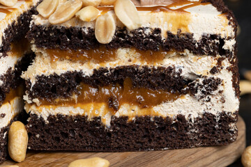 a piece of chocolate cake with caramel and peanuts