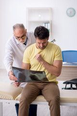 Obraz premium Young male patient visiting old male doctor radiologist