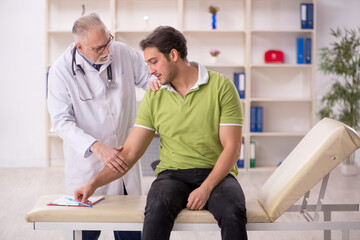 Fototapeta premium Young male patient visiting old male doctor