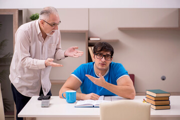 Young male student and his grandfather at home