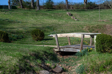 Obraz na płótnie Canvas Idyllic grassy garden with backyard foot bridge