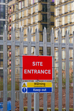 Site entrance sign on fence boundary at construction site