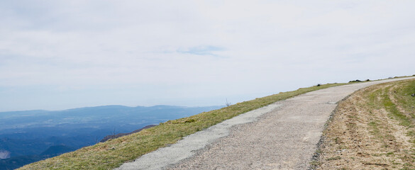 Fototapeta premium Sphalted road up the mountain with views of part of the Maresme, Barcelona. Hiking route in Montseny, Catalonia, Spain. Space for text.