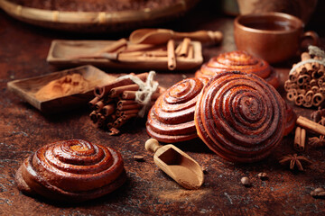 Freshly baked cinnamon buns on a brown table.